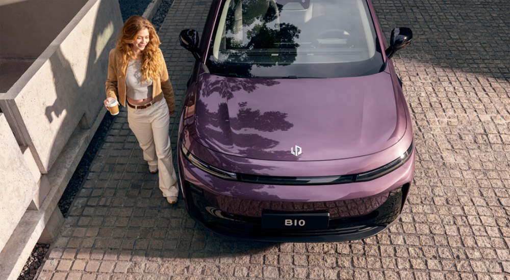 A person walking next to a purple Leapmotor B10 Hybrid EV.