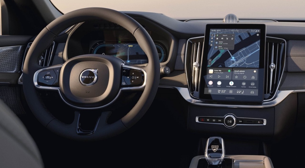 Interior of a Volvo XC90 showing steering wheel and display; Volvo XC90 used car safety and technology