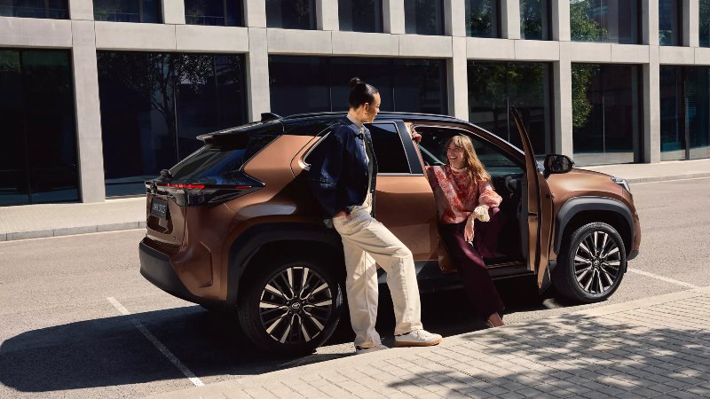 new Toyota Yaris with 2 people next to it