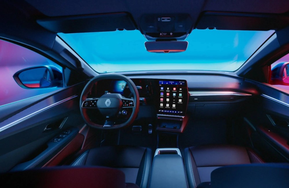 Interior shot of the driver cockpit of a Renault Megane E-Tech Electric, showing off the infotainment system and driving position.