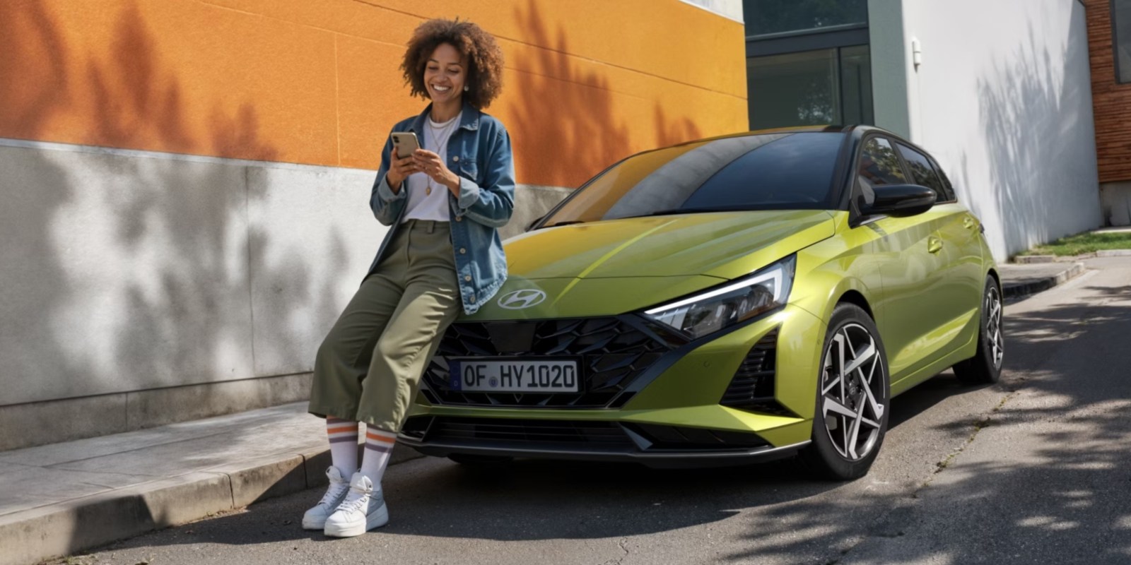 Person leaning on a Hyundai i20 car whilst on their phone; Hyundai Leasing