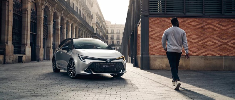 New Toyota corolla parked with man walking towards it