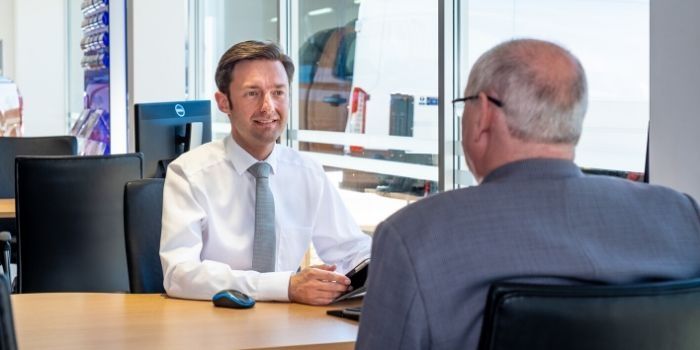finance stoneacre finance team talking with a customer in a showroom