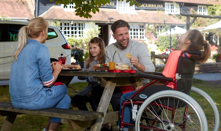 Motability new vehicle payment; family outside eating