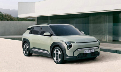 A green Kia EV 3 parked outside a contemporary home; How EVs work intro image