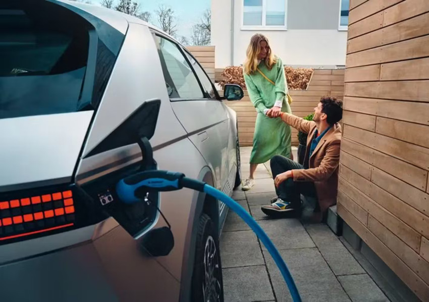 A couple joke around whilst a Hyundai IONIQ 5 charges; Charging an EV at home image