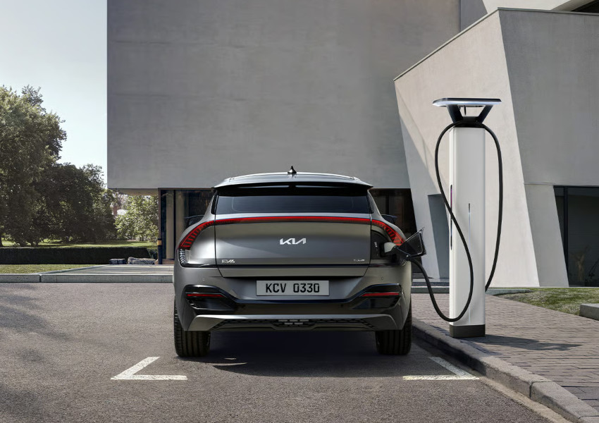 A gret Kia EV 6 charges at the side of the road; Charging an EV at a public point image