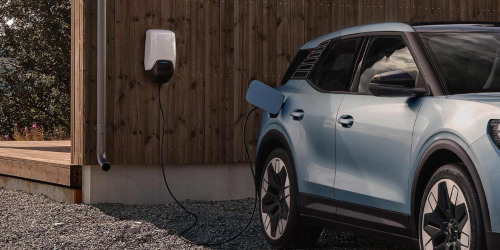A blue Ford Explorer charges; EV home charger installation intro image