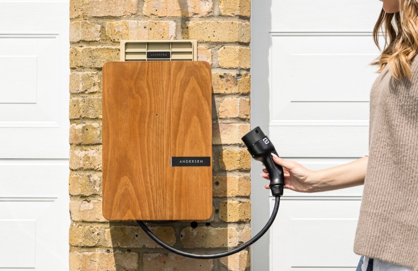 A contemporary looking home EV charger held by a woman; EV home charger brands image