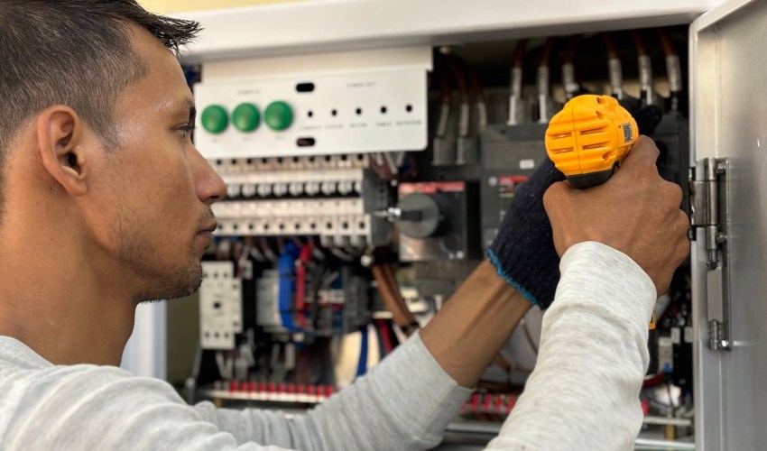 A technician works on an a home's electricity board; Home EV charger maintenance image