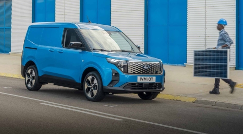 Ford E-Transit Courier - Front View A man carrying a solar panel walks towards a new Ford E-Transit Courier in Digital Aqua Blue.