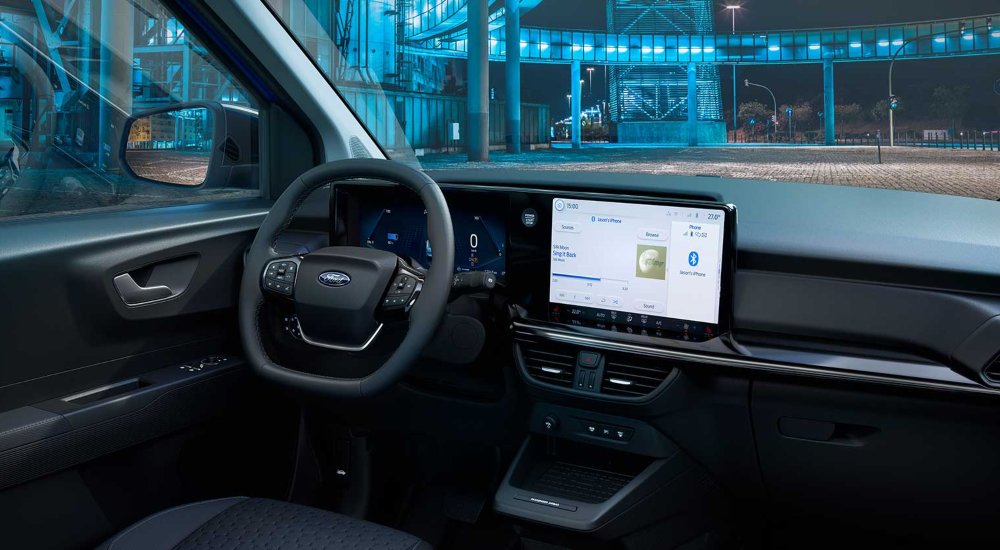 The interior of a new Ford E-Transit Courier, showing the dashboard, steering wheel, and centre console.