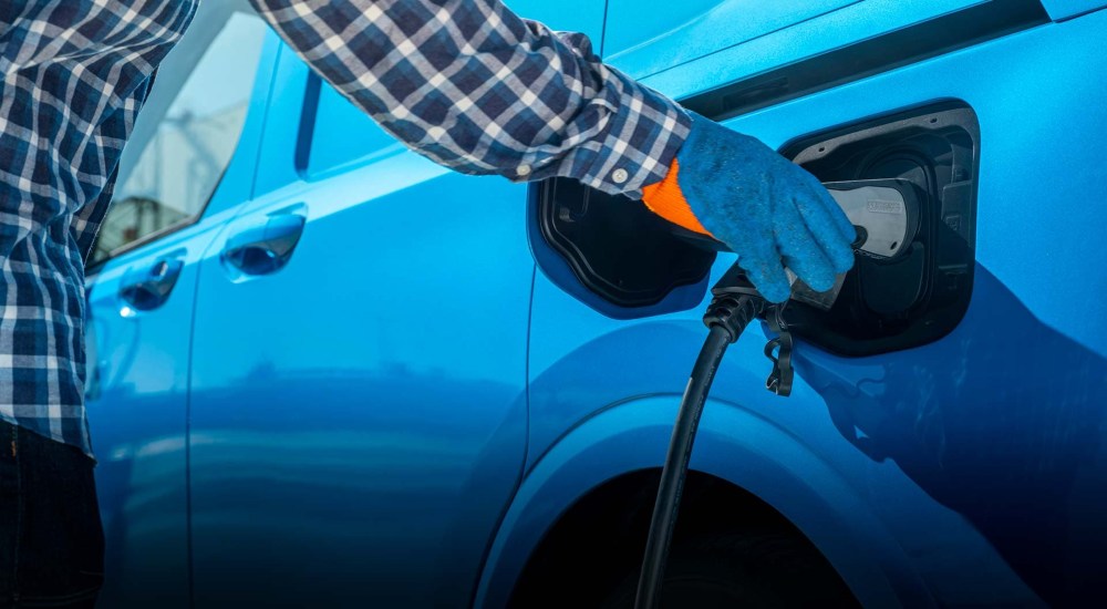 Ford E-Transit Courier - Charging Port Person plugs a new Ford E-Transit Courier, in Digital Aqua Blue, in to charge.