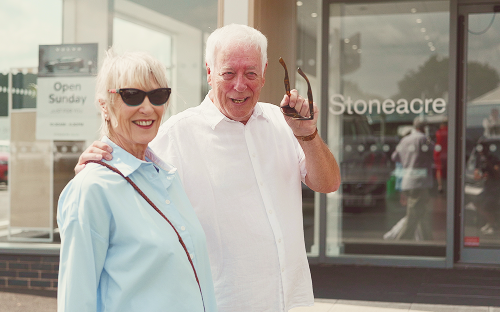 An older couple look over a blue Renault Rafale; Joint application for bad credit image.