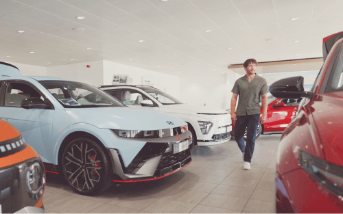 Man walks through a Hyundai showroom; Car finance broker vs Lender image