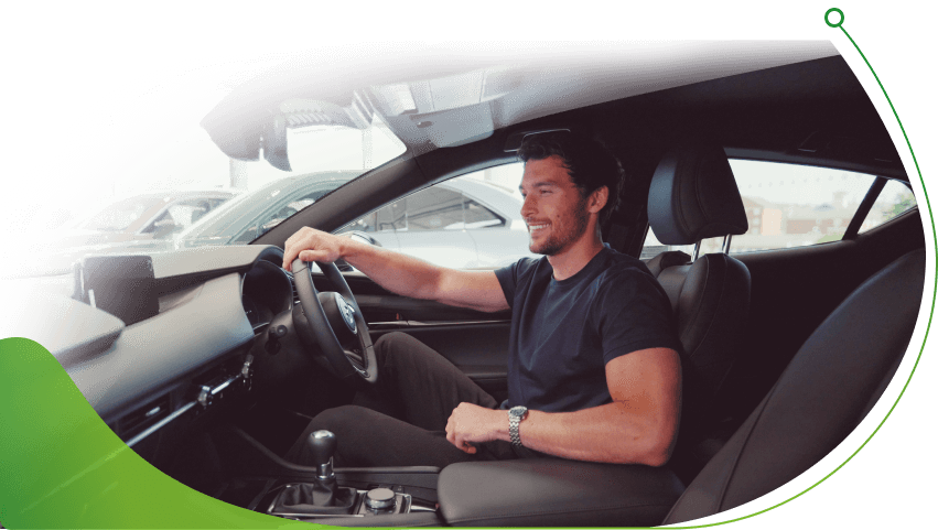 A man sits in the cabin of a new car; Personal contract hire car deals image