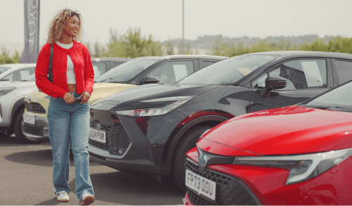 A woman walks through a car dealer forecourt; Car finance for people on benefits with bad credit image