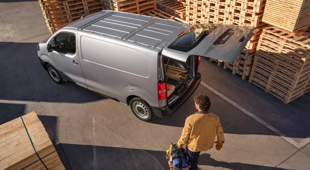 New Toyota Proace van in warehouse yard, with open rear cargo space for loading.