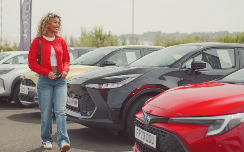 A woman walks past cars; How to Get Car Finance as a Student image