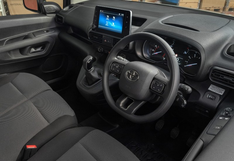 Used Toyota Proace City interior with steering wheel, touchscreen display and front seats.