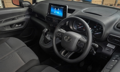 Used Toyota Proace City interior with steering wheel, touchscreen display and front seats.