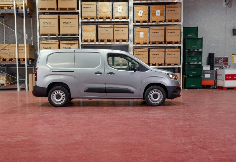 Used Toyota Proace City for sale, side profile of commercial van in warehouse setting.
