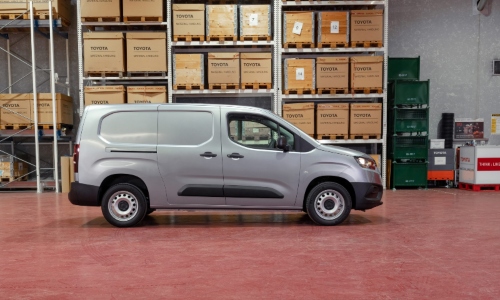 Used Toyota Proace City for sale, side profile of commercial van in warehouse setting.