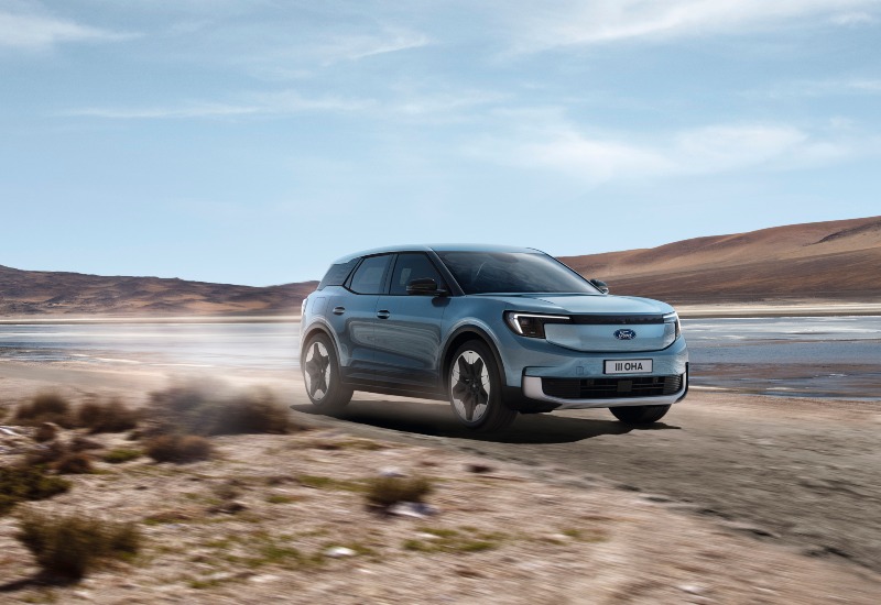 Used Ford Explorer UK Used Ford Explorer SUV driving in the UK countryside with mountains in the background.
