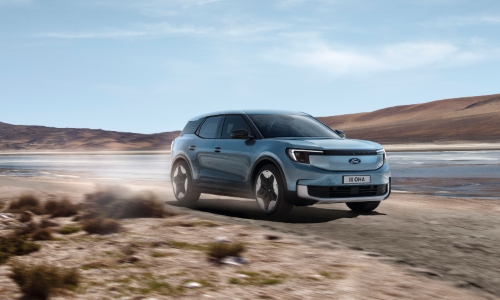 Used Ford Explorer UK Used Ford Explorer SUV driving in the UK countryside with mountains in the background.