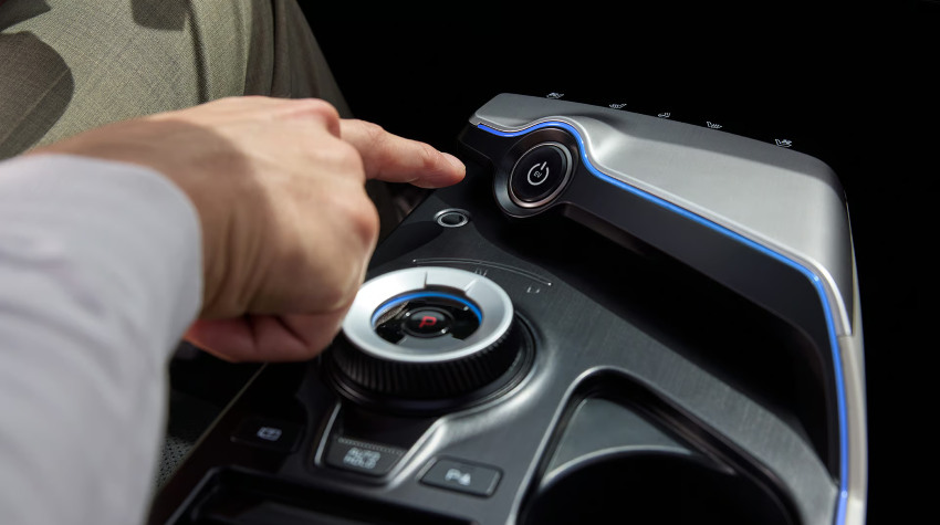 A driver goes to push a button to turn on an EV car; EV best practices image