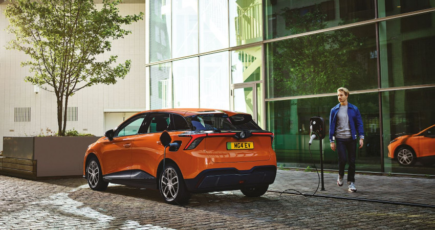 A man sets up charging for an orange MG 4 EV; EV charging network image