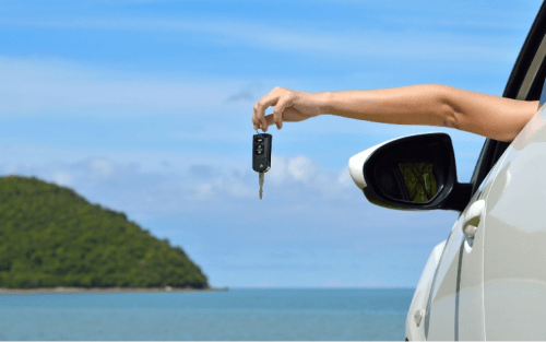 A driver holds a car key our of a car window; Oodle Car Finance at Stoneacre image