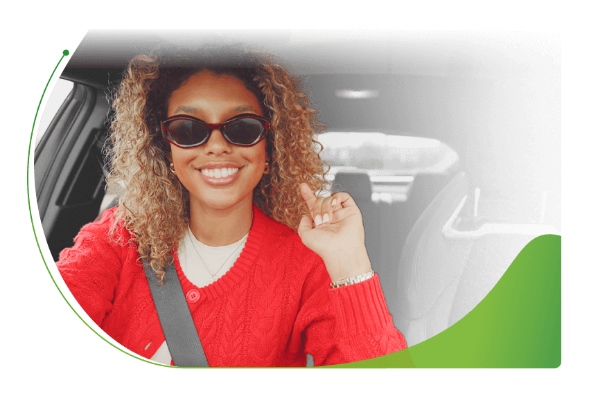 A woman with sunglasses on in the driver's seat of a car; How to get Car Finance on Benefits image