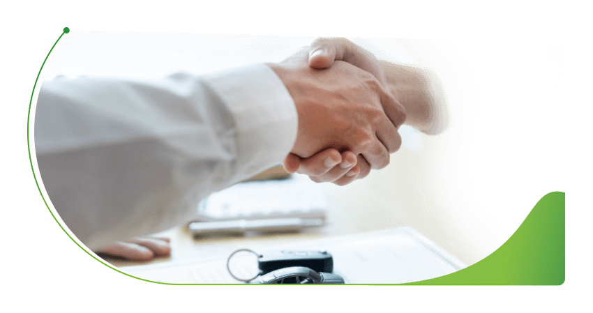 Two people shake hands at a desk; About Advantage car finance image