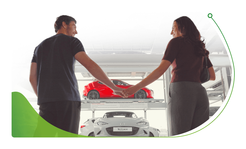 Two people hold hands in a car dealership; Who can be a guarantor image