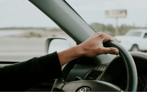 A hand rests on the top of a steering wheel; Marsh Finance at Stoneacre image