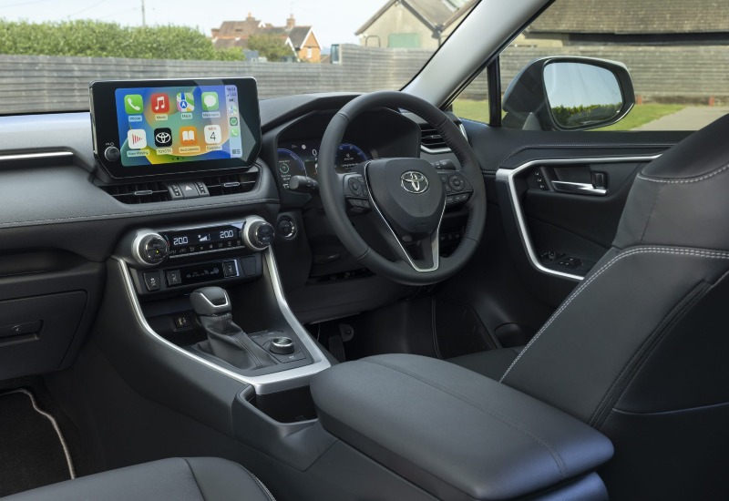 Used Toyota RAV4 Hybrid interior with a touchscreen, leather steering wheel and seats.
