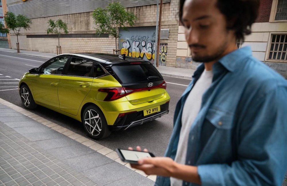 Person using the My Hyundai app near a new i20 Person using the My Hyundai app near a new i20