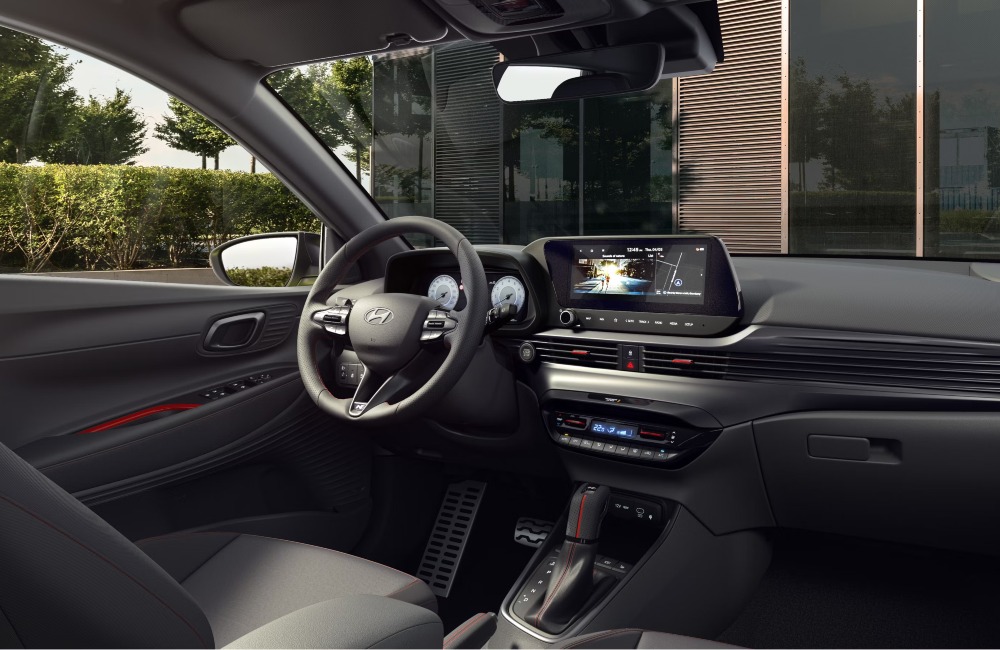 The interior of a new Hyundai i20, showing the drivers seat, steering wheel, and infotainment systems