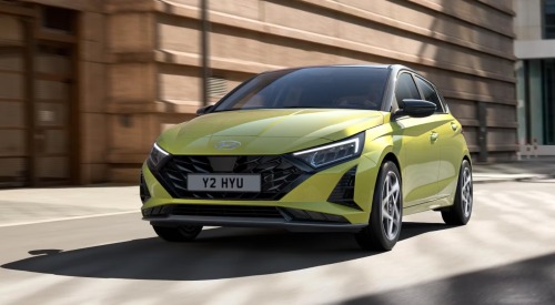 A new Hyundai i20 driving around a city corner at speed A new Hyundai i20 driving around a city corner at speed