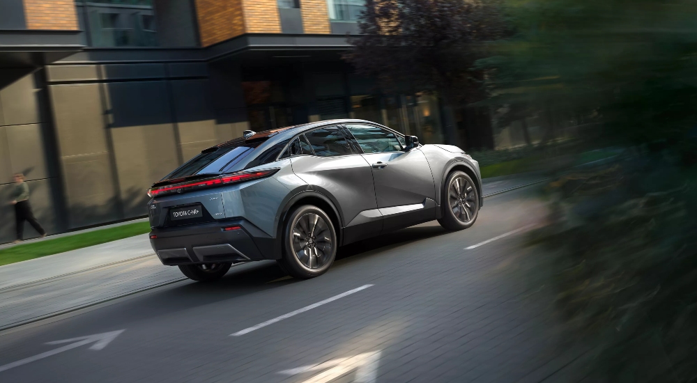 New Toyota C-HR+ driving on the road, showing Toyota Safety Sense features for driver assistance and passenger protection.