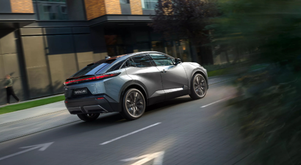 New Toyota C-HR+ driving on the road, showing Toyota Safety Sense features for driver assistance and passenger protection.
