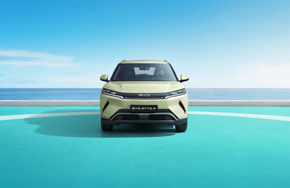 The front of a new BYD ATTO 2, with the backdrop of a calm ocean