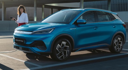 BYD ATTO 3 about to be plugged in to charge by a person in formal attire