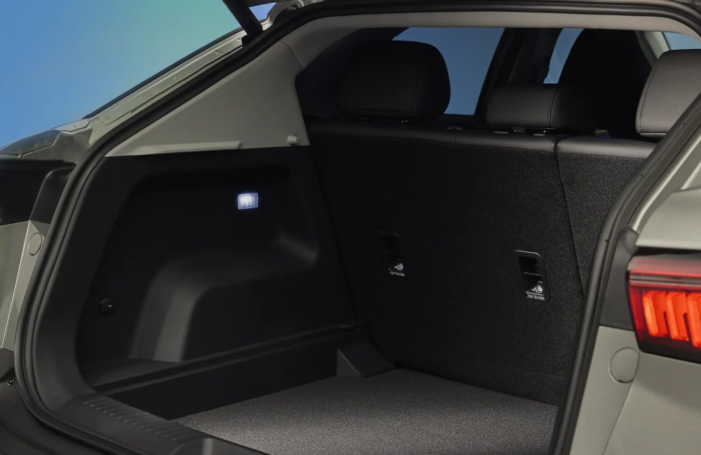 Rear view of a new OMODA 5, showing the rear tailgate open leading to a vast cargo space with internal lighting