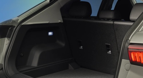 Rear view of a new OMODA 5, showing the rear tailgate open leading to a vast cargo space with internal lighting