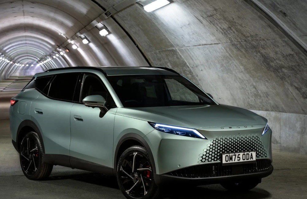 Angled front view of a new OMODA 7 in a long tunnel with lighting, showing lit LED lights and its unique grille and sidelines