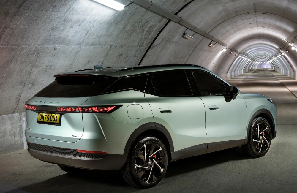Rear-angled view of a parked OMODA 7 in a long lit tunnel, showing off the bold stance and rear LED lighting.