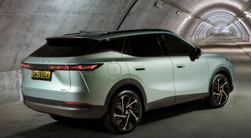 Rear-angled view of a parked OMODA 7 in a long lit tunnel, showing off the bold stance and rear LED lighting.