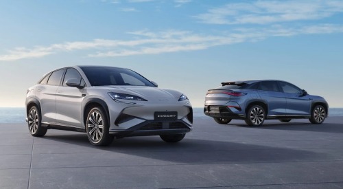 Two used BYD cars parked near one another with a scenic sunrise backdrop. One car is at a forward angle, with the other showing off an angled side shot